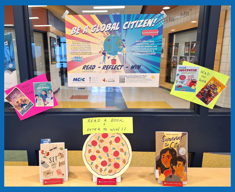 A book display at a school library showing the Be a Global Citizen poster, a number of books and a picture of a pizza